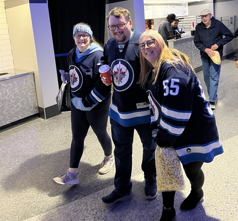 Three sports fans smiling at the camera