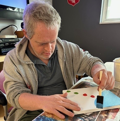 A man painting a canvas